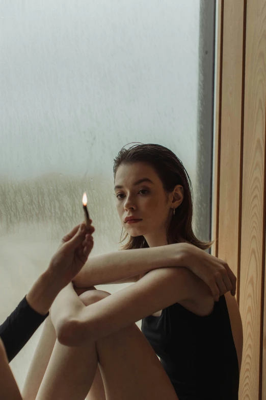 a woman sitting on a window sill holding a lit candle, inspired by Elsa Bleda, visual art, holding a small vape, profile image, elle fanning), ignant