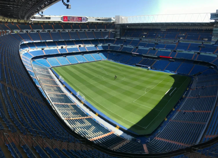 a soccer stadium with blue seats and a green field, a picture, instagram, madrid, 15081959 21121991 01012000 4k, big windows, square