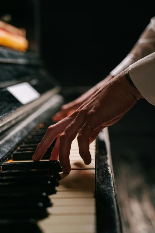 a close up of a person playing a piano, by Ottó Baditz, pexels, precisionism, right hand side profile, paul barson, vintage color, hands reaching for her