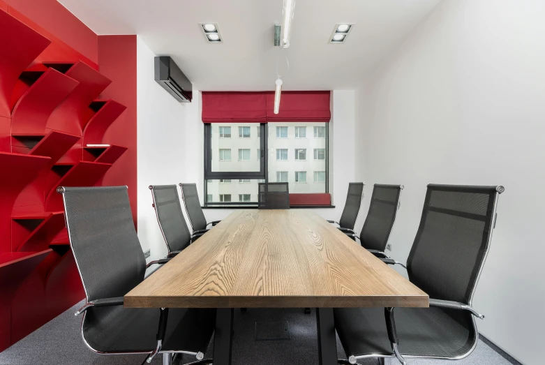 a conference room with a wooden table and black chairs, by Adam Marczyński, accents of red, located in hajibektash complex, thumbnail, square