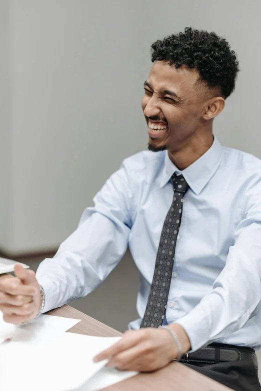 a man in a blue shirt and tie sitting at a table, inspired by Afewerk Tekle, pexels contest winner, earing a shirt laughing, commercial banner, court session images, coworkers