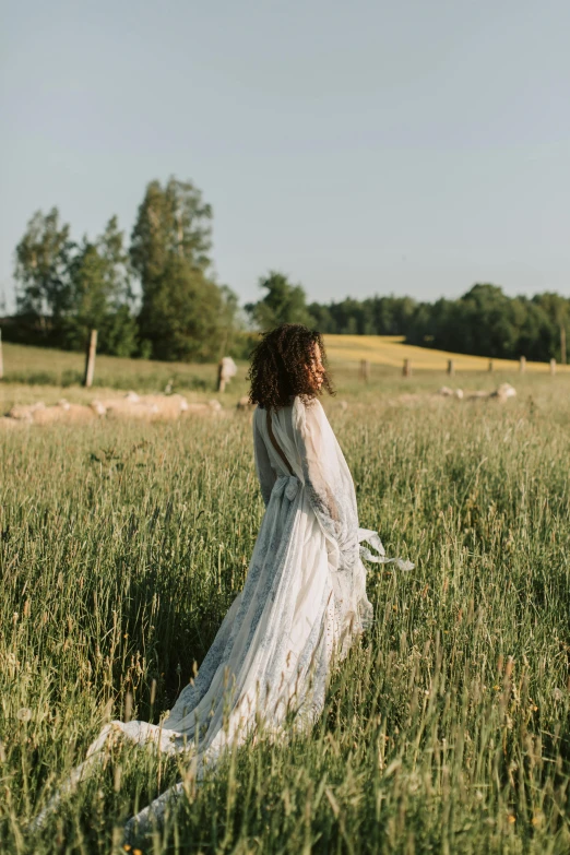 a woman standing in a field of tall grass, by Anna Boch, unsplash, in a long white dress, swedish countryside, walking down, farming