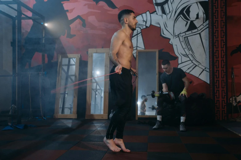 a shirtless man holding a sword in a gym, by Emma Andijewska, khabib, full body image, b - roll, mohamed chahin style