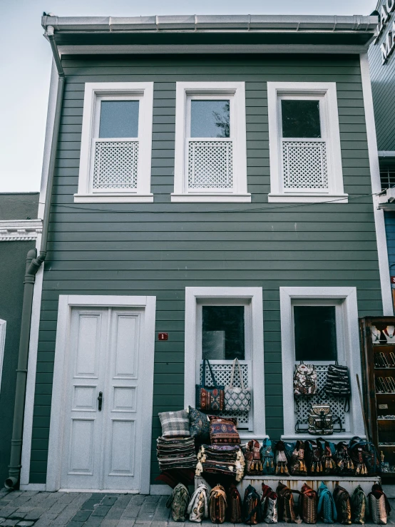 a building with a bunch of stuffed animals in front of it, a photo, pexels contest winner, hurufiyya, blue shutters on windows, reykjavik, istanbul, small scandinavian!!! houses