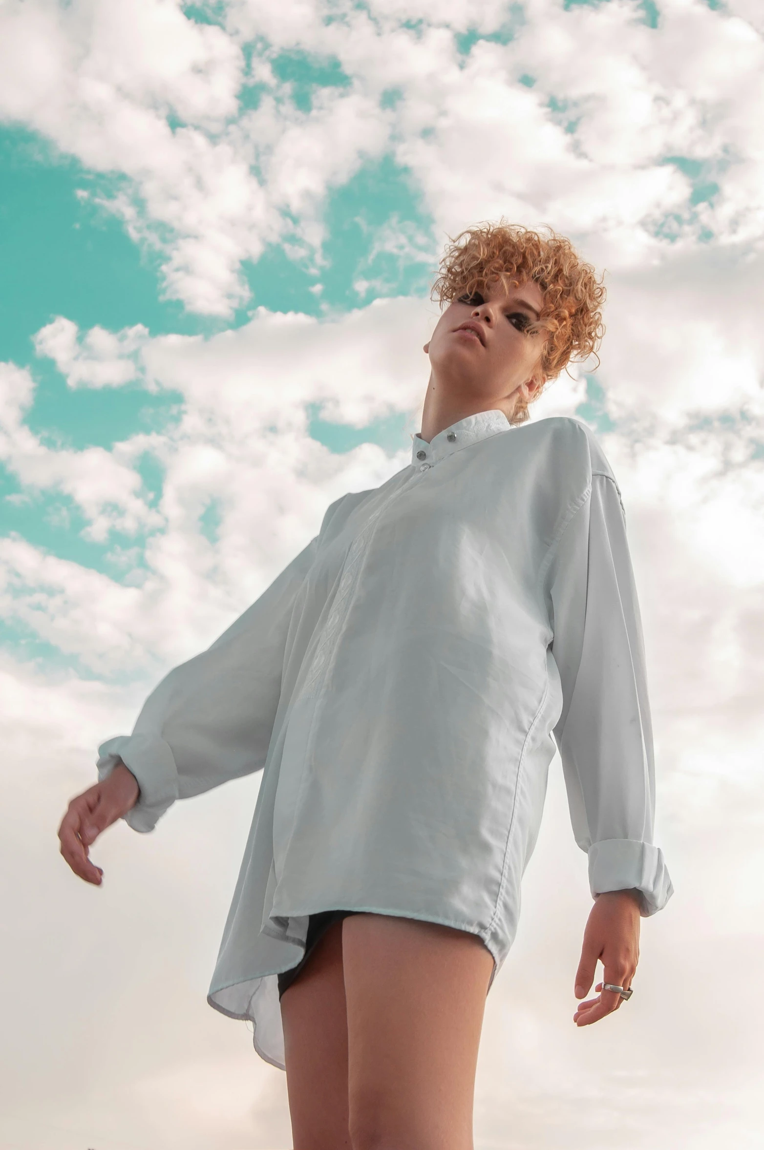 a woman standing on top of a sandy beach, an album cover, trending on pexels, renaissance, button up shirt, redhead woman, standing on a cloud, attractive androgynous humanoid