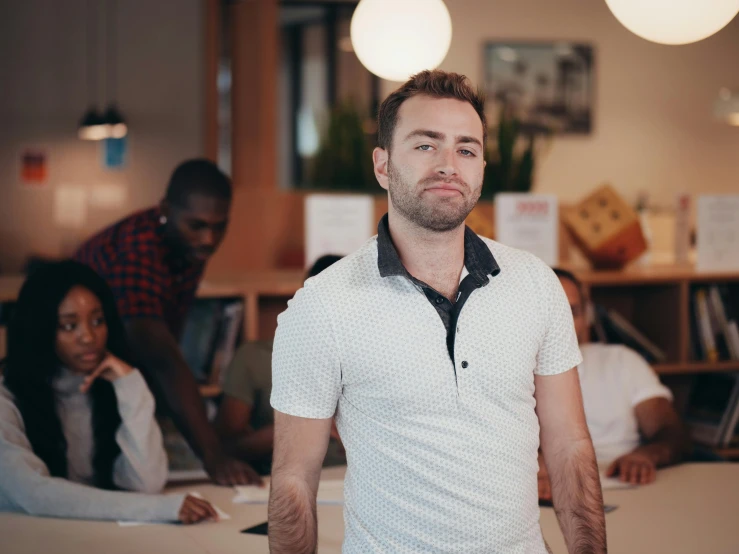 a man standing in front of a group of people, on a desk, highly upvoted, smirking, lachlan bailey