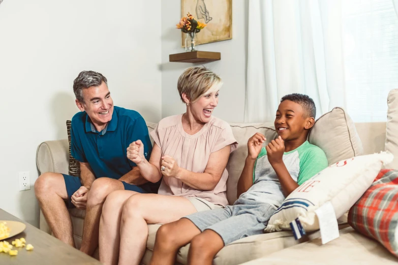 a group of people sitting on top of a couch, families playing, extra crisp image, laughing, husband wife and son