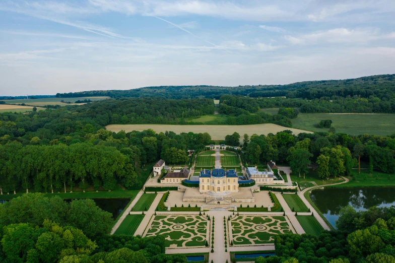 an aerial view of a large mansion surrounded by trees, by Romain brook, rococo, pur champagne damery, inside a grand, sky view, a park