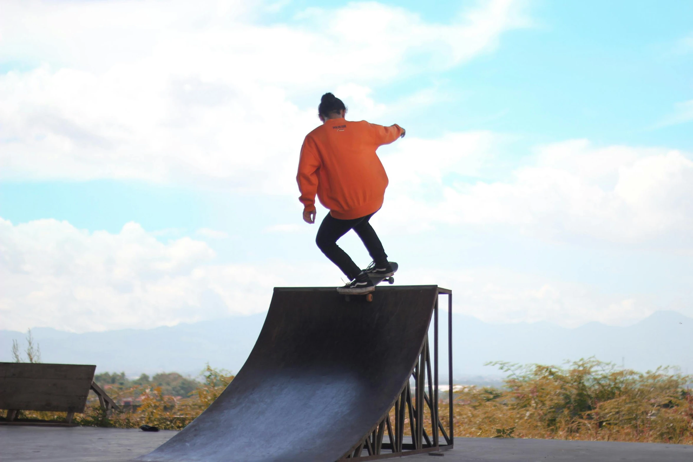 a man riding a skateboard up the side of a ramp, avatar image, no cropping, mountains in the background, cindy avelino