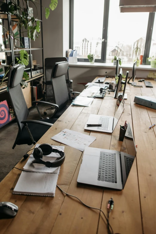 a laptop computer sitting on top of a wooden desk, in a open-space working space, profile image, 9 9 designs, panoramic shot