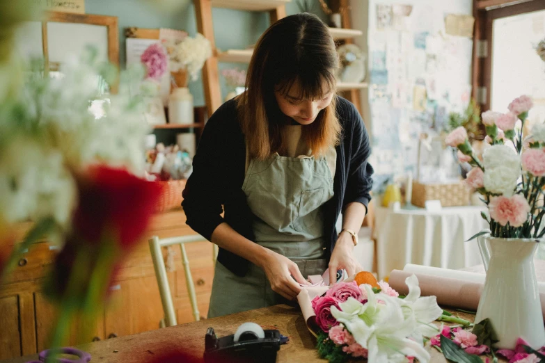 a woman making a flower arrangement in a flower shop, pexels contest winner, arts and crafts movement, artist wearing overalls, gemma chen, sydney hanson, profile image