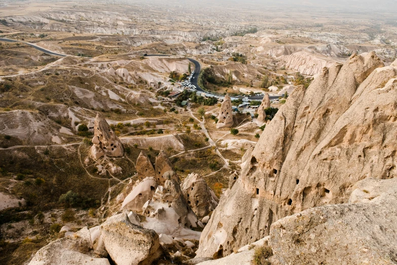 a view of the valley from the top of a mountain, by Muggur, pexels contest winner, art nouveau, buildings carved out of stone, beige, mills, 2000s photo