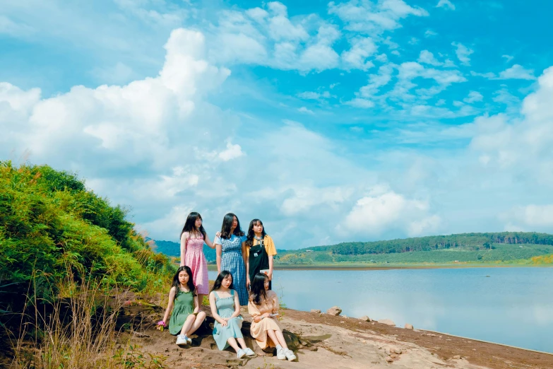 a group of people sitting next to a body of water, an album cover, inspired by Ni Yuanlu, unsplash, hurufiyya, cute girls, blue sky, in girls generation, avatar image