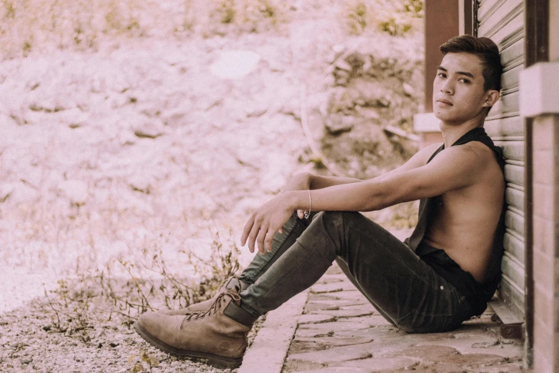 a shirtless man sitting on the side of a building, unsplash, renaissance, wearing a camisole and boots, teenage jughead jones, asian human, lgbtq