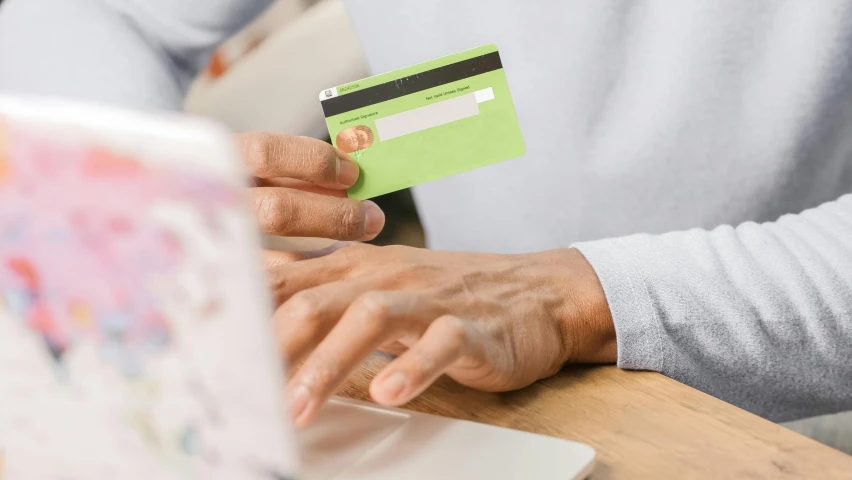 a person holding a credit card in front of a laptop, a digital rendering, pexels contest winner, private press, pastel green, uk, profile image, loosely cropped