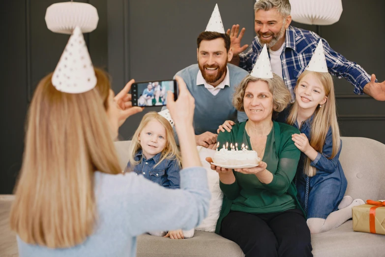 a woman taking a picture of a family celebrating a birthday, pexels contest winner, figuration libre, wearing a grey wizard hat, people enjoying the show, birthday cake, profile image