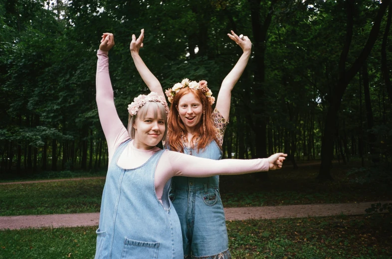 a couple of women standing next to each other, pexels contest winner, kitsch movement, triumphant pose, midsummer, pale - skinned, in the park