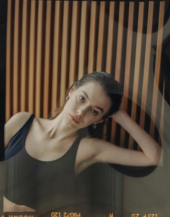 a woman that is standing in front of a mirror, a polaroid photo, inspired by Elsa Bleda, trending on pexels, photorealism, kiko mizuhara, wearing a tanktop, portrait mode photo, desaturated