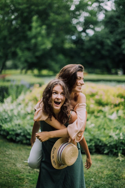 a couple of women standing on top of a lush green field, a picture, by Emma Andijewska, pexels contest winner, playful smile, brunette, in a park, 15081959 21121991 01012000 4k