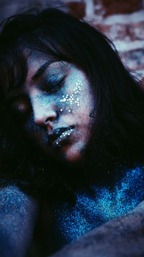 a close up of a person with glitter on their face, an album cover, inspired by Elsa Bleda, trending on pexels, holography, ((blue)), dreaming bodies, grainy vintage, high quality photo