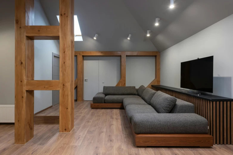 a living room filled with furniture and a flat screen tv, by Adam Marczyński, light and space, wooden house, grey, large couch, 8k octan photo