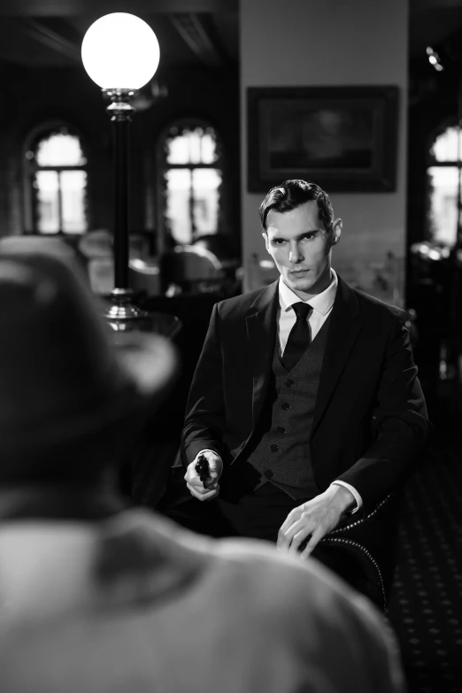 a black and white photo of a man in a suit, inspired by Yousuf Karsh, tumblr, benedict cumberbatch, in a dark dusty parlor, movie still 8 k, promo image