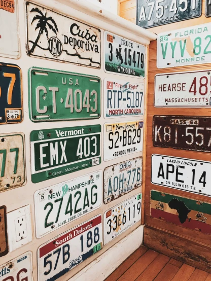 a room filled with lots of license plates on the wall, by Carey Morris, trending on unsplash, 🚿🗝📝, instagram story, high angle close up shot, new hampshire