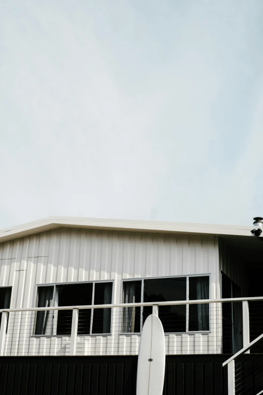 a house with a surfboard in front of it, hangar, galvalume metal roofing, view from bottom, dwell