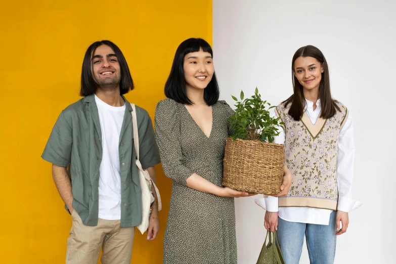 three people standing next to each other holding a plant, pexels contest winner, diverse outfits, presenting wares, post graduate, sustainable materials