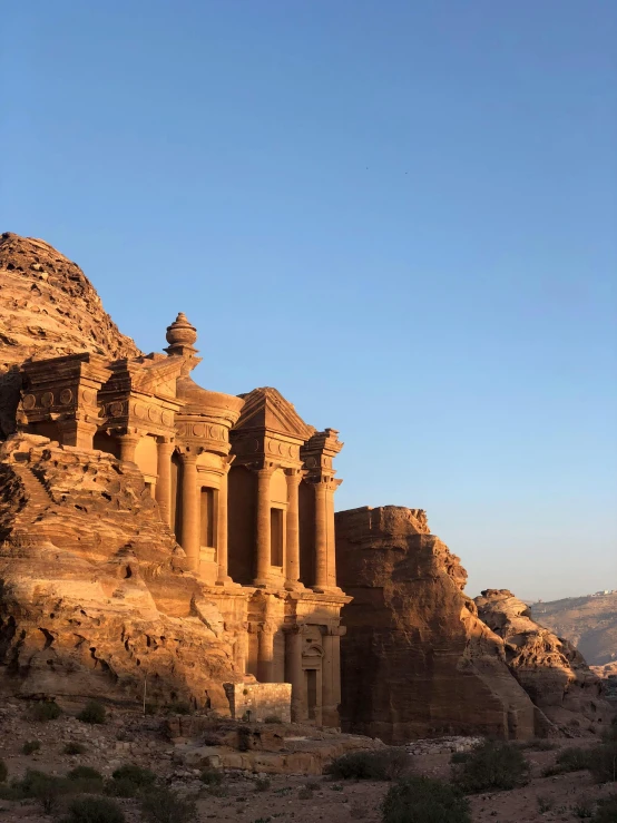 a large building built into the side of a mountain, pexels contest winner, neoclassicism, jordan, temple in the background, hard morning light, instagram story