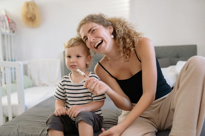 a woman and a child sitting on a bed, pexels contest winner, happening, holding a syringe, avatar image, australian, dimples