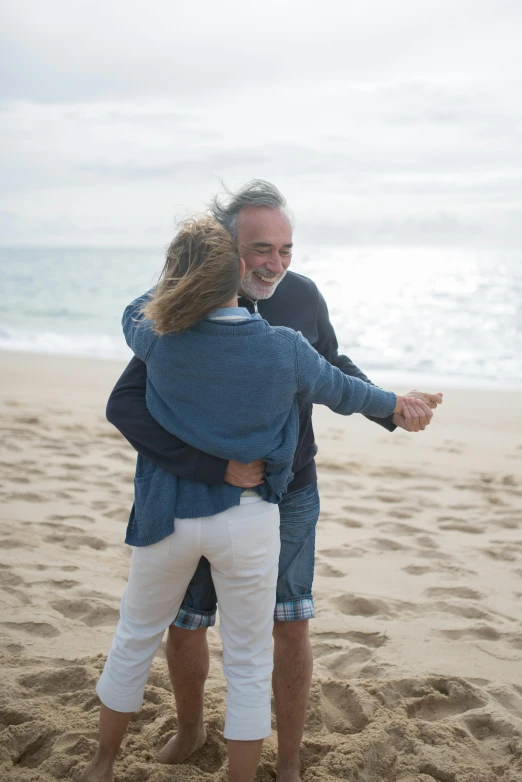 a man and a woman hugging on the beach, happening, beachfront, twirling, older male, denim