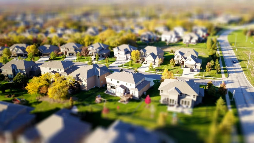 a group of houses sitting on top of a lush green field, a tilt shift photo, pexels contest winner, photorealism, suburban neighborhood, 3d models, 2000s photo