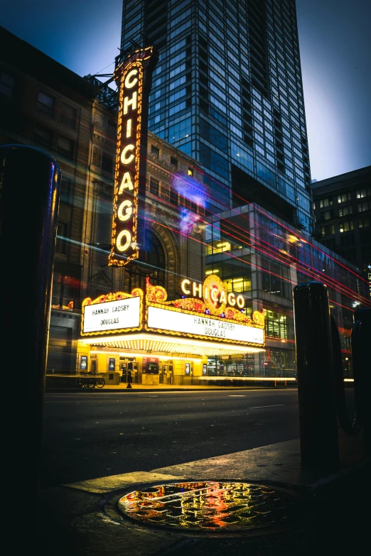 the chicago theater marquee is lit up at night, pexels contest winner, graffiti, movie photo, glass buildings, yellow lights, distant photo