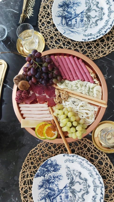 a close up of a plate of food on a table, cheese and salami on the table, thumbnail, profile image
