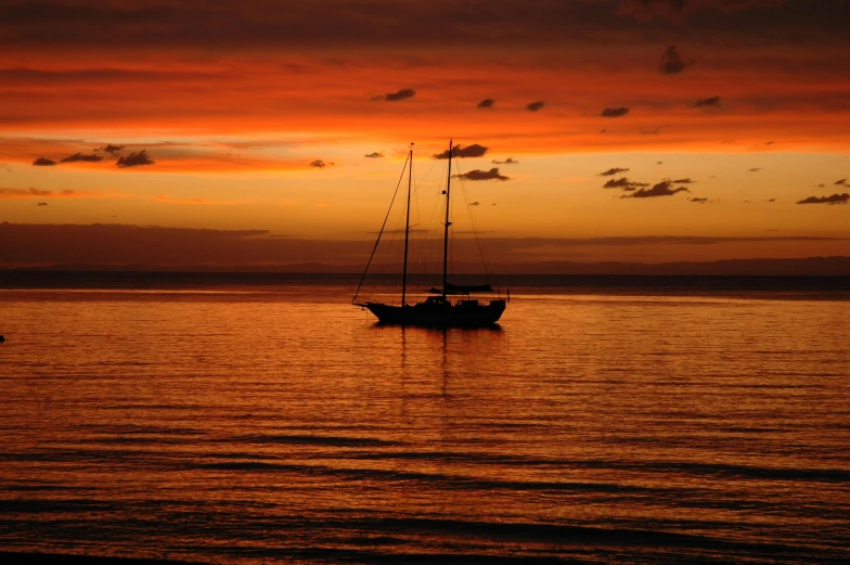 a couple of boats floating on top of a body of water, pexels contest winner, romanticism, orange and red sky, sailboat, jamaica, abel tasman