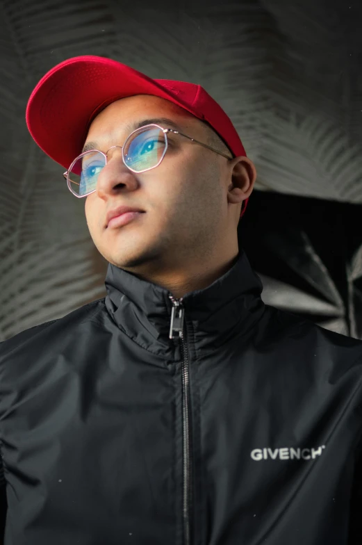a man wearing glasses and a red hat, an album cover, inspired by Dom Qwek, trending on pexels, in a black hoodie, raden saleh, lgbtq, bald on top