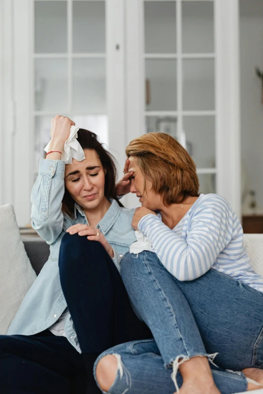 a couple of women sitting on top of a couch, trending on pexels, incoherents, crying tears, first aid kit, low quality photo, injured