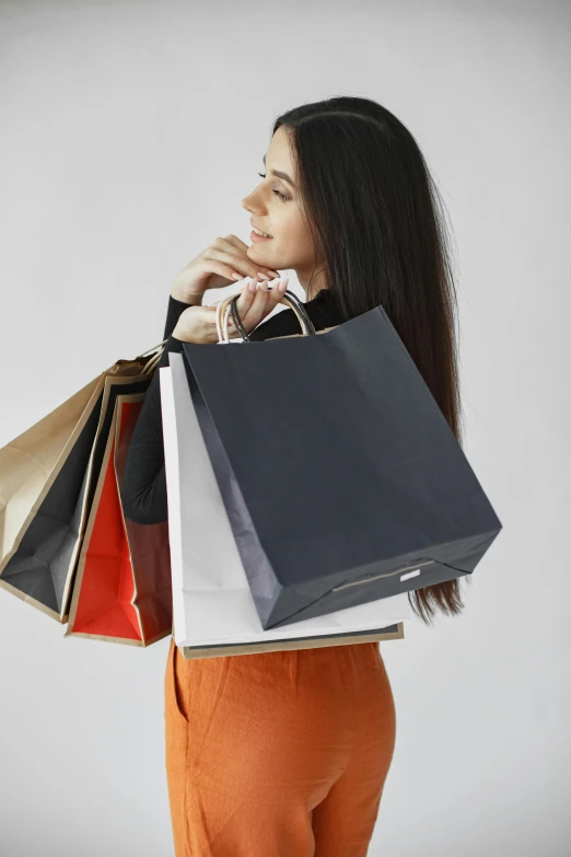 a woman holding a bunch of shopping bags, pexels contest winner, renaissance, on a gray background, dua lipa, square, at a mall