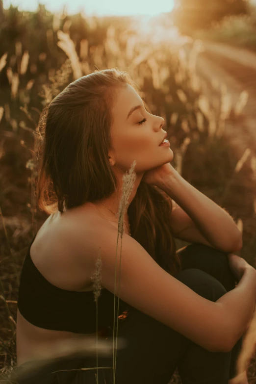 a woman sitting in the middle of a field, trending on pexels, backlit beautiful face, 5 0 0 px models, profile pic, ambient amber light