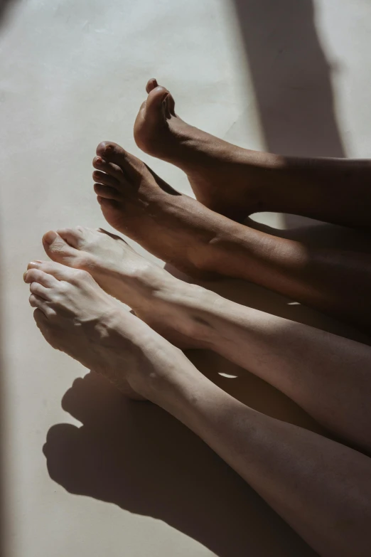 a group of feet sitting next to each other, high radiosity dull skin, smooth shadows, darker skin, sunfaded