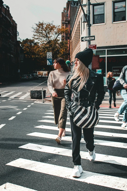 a group of people walking across a crosswalk, trending on pexels, woman in streetwear, new york city, white and black clothing, instagram post