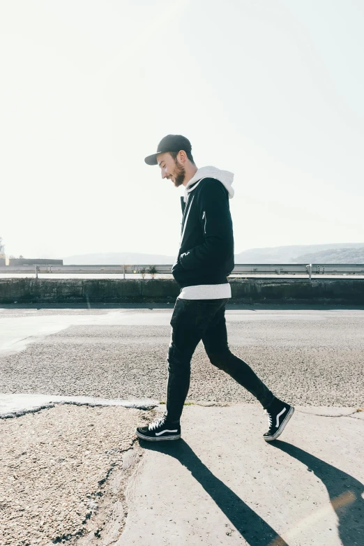 a man walking across a street with a skateboard, unsplash, minimalism, wearing a black hoodie, looking off to the side, wearing fitness gear, full body photo of steve