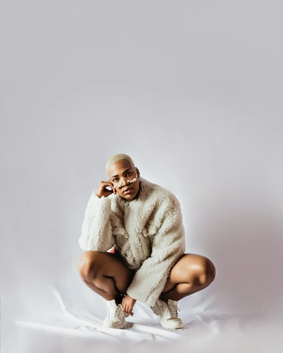 a woman sitting on top of a pile of luggage, by Dulah Marie Evans, white short hair, teddy fresh, androgynous male, wearing a luxury fur coat