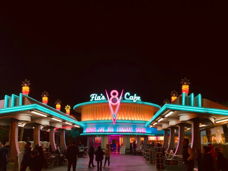 a couple of people that are standing in front of a building, by Ryan Pancoast, pexels contest winner, retrofuturism, at california adventure, nightcafe, eight eight eight, teal lights