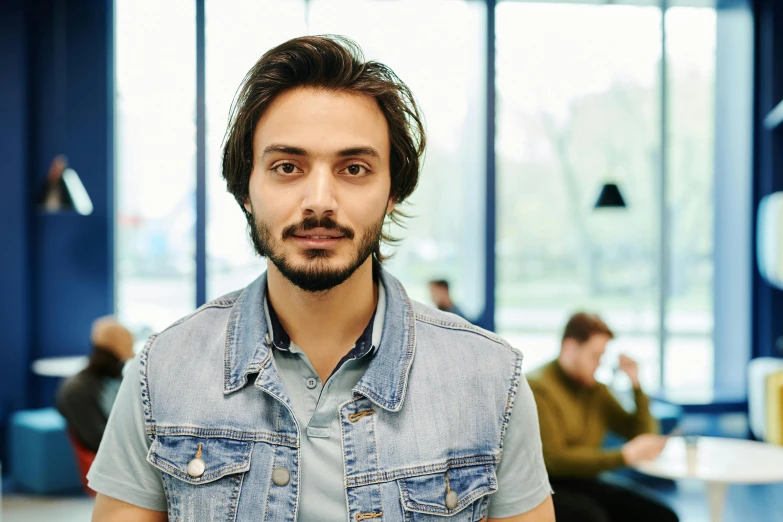 a man with a beard standing in an office, pexels contest winner, portrait of a young italian male, standing in class, avatar image, lachlan bailey