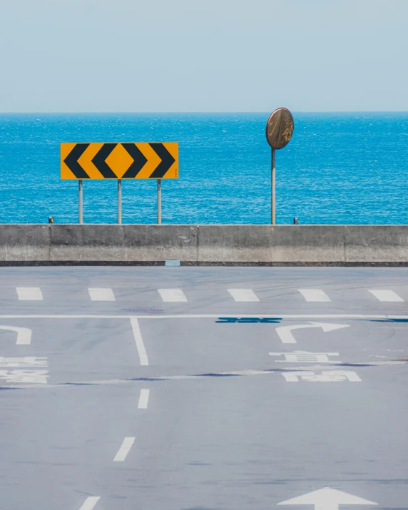 an empty parking lot next to the ocean, an album cover, unsplash, traffic signs, new zealand, trending on art, runway