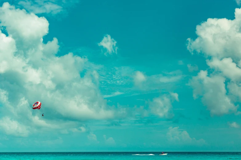 a person parasailing in the ocean on a sunny day, pexels contest winner, fine art, red and cyan theme, avatar image, high clouds, caribbean