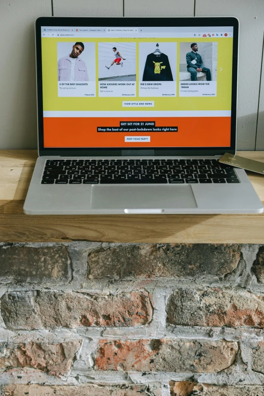 a laptop computer sitting on top of a wooden desk, by Carey Morris, pexels, yellow and black color scheme, 9 9 designs, construction, front on