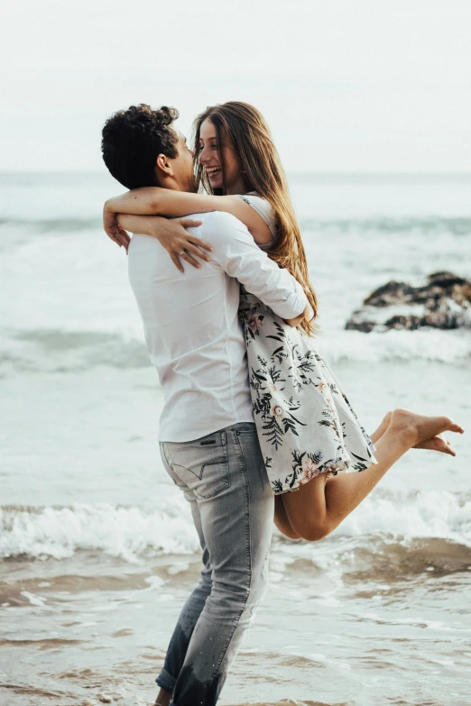 a man is hugging a woman on the beach, pexels contest winner, all overly excited, pokimane, romantic lead, half image